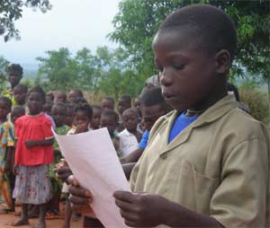 Un jeune orphelin au Bénin lisant une lettre de sa marraine