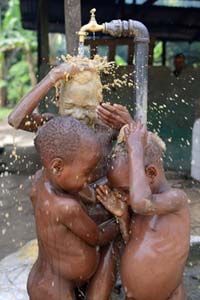 Après le bain de boue, une douche pour les enfants Pygmées Bagyeli de Bipindi au Cameroun
