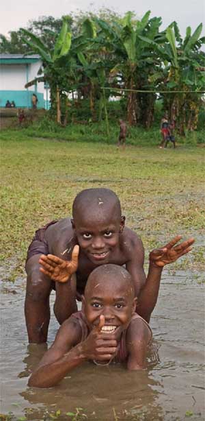 Enfants Pygmées mangeant des mangues au réveil, Bipindi, Cameroun