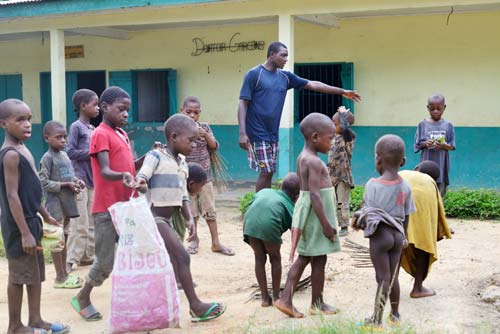 Rammasage des papiers dans la cour du Fondaf par les enfants Pygmées Bagyeli de Bipindi au Cameroun