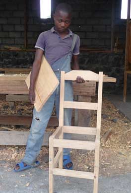 Muhindo présente la chaise qu'il vient de fabriquer