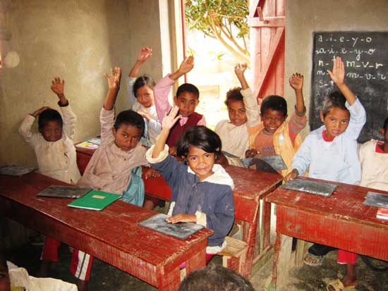 Les élèves lèvent le doigt pour répondre dans leur école de Madagascar