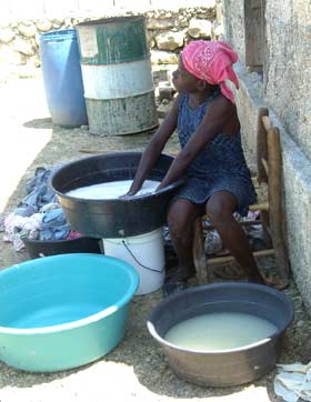 Enfant faisant la lessive dans une ruelle du bidonville de Cité Soleil en Haïti