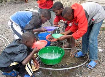 Après le repas, les enfants des rues participent au nettoyage et à la vaisselle